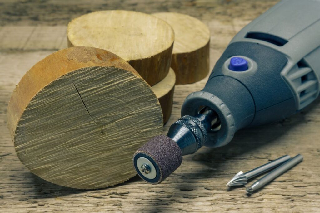 A rotary tool with 2 burrs beside some cut woods