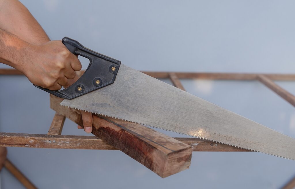 using a hand saw to cut 4x4