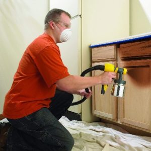 image of a woodworker using the best hvlp spray gun for wood finishing