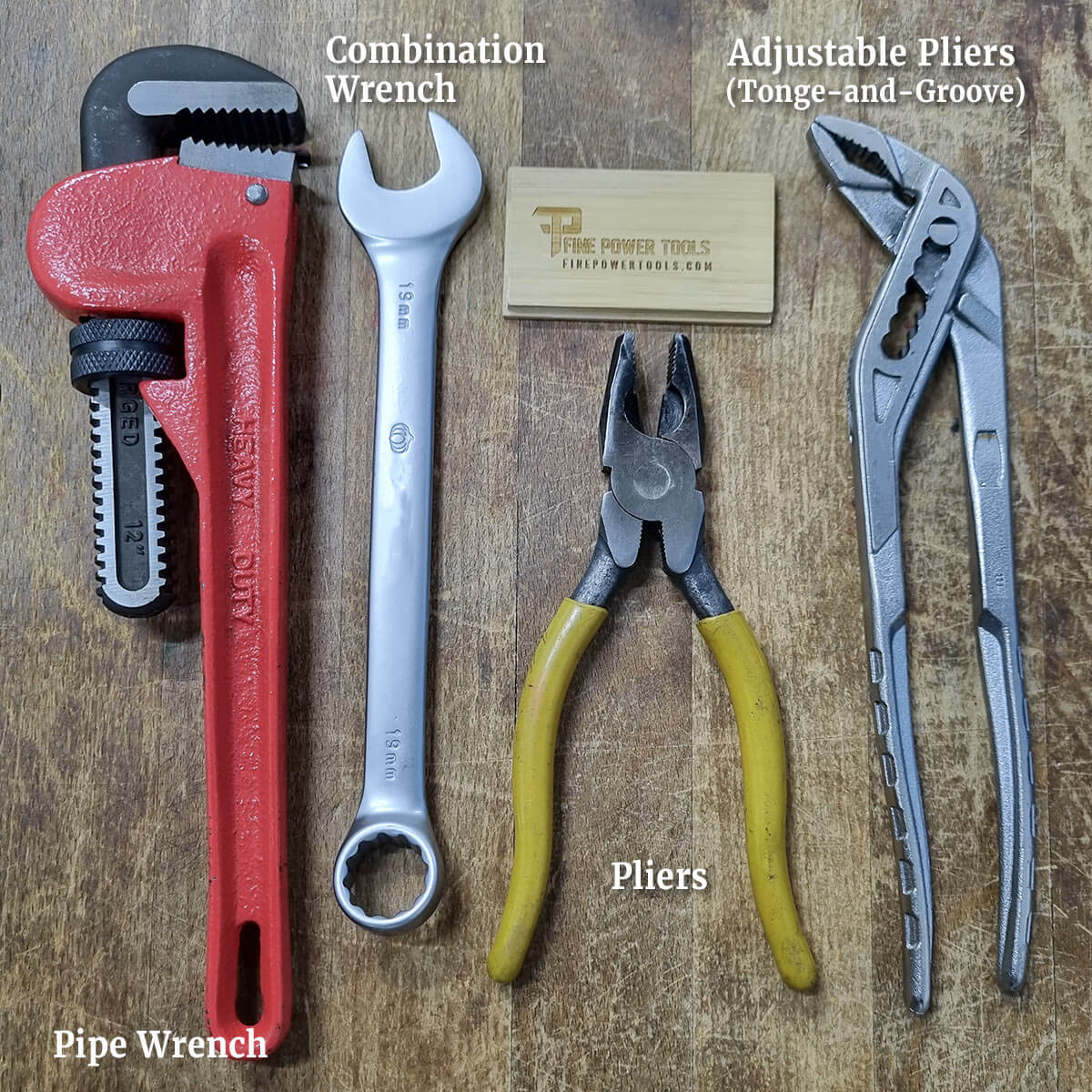 Wrenches and Pliers comparison: A pipe wrench, combination wrench, and pliers on wooden bench